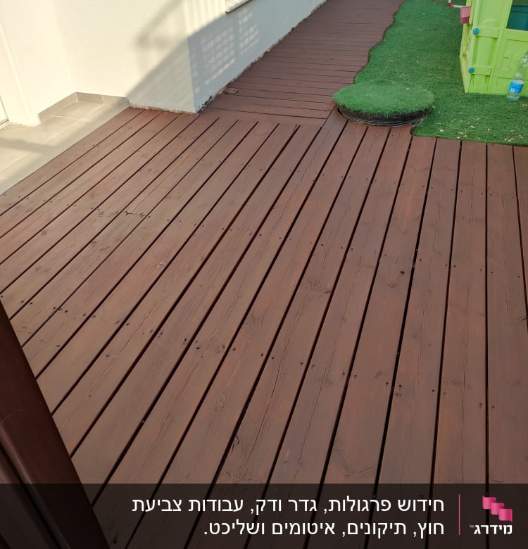 דק עץ חום ליד דשא סינתטי וצעצועים